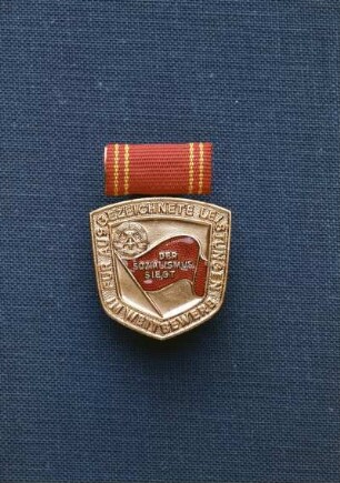 Medaille für ausgezeichnete Leistungen im Wettbewerb : Medaille für ausgezeichnete Leistungen im Wettbewerb. Medaille an Spange (rot emailliert; 1953 gestiftet). Avers