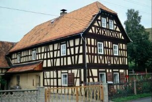 denkmalgeschütztes FW-Haus, Krüppelwalm, Vordach an Traufsseite, Vorgarten