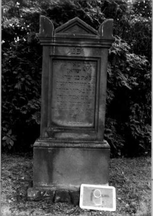 Grabstein 9 (Index: 100110404) Material: Sandstein Zustand: verwittert Maße HxBxT: 136x57x17 cm Beschreibung: Stele, getreppter Sockel, unterer Sockel rusticaartig, Giebel mit Eckakroteren, Schriftfeld rechteckig: Grabstein 9