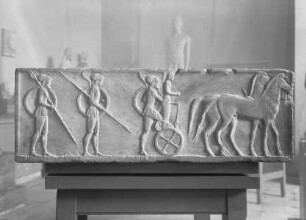 Dreiseitig reliefierte Basis eines Kuros — linke Nebenseite: Hopliten und Streitwagen