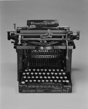 Typenhebelschreibmaschine "Remington" (Modell 7). Unteranschlag (nicht sofort sichtbare Schrift), Universaltastatur mit 42 Tasten, 23-mm-Farbband. Vorderansicht : Typenhebelschreibmaschine "Remington" (Modell 7). Unteranschlag (nicht sofort sichtbare Schrift), Universaltastatur mit 42 Tasten, 23-mm-Farbband. Vorderansicht. Baujahr: ab 1898; Hersteller: Remington and Sons Ilion, N. Y. Verwalter: Sächsische Landesbibliothek - Staats- und Universitätsbibliothek Dresden (SLUB), Stenografische Sammlung, Inventar-Nummer R i 0004