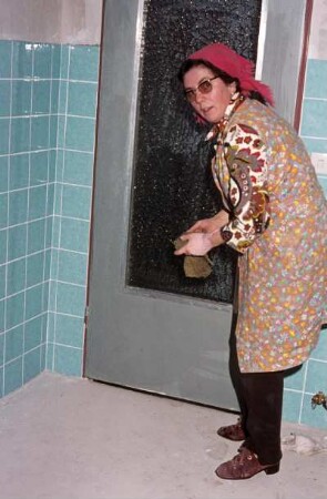Frau mit Putzlappen in einer Kellerküche
