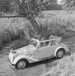 Personenkraftwagen Borgward Hansa 1100 Cabriolet mit offenem Verdeck in einem Gewässer, auf der Rückbank sitzt das Kind der Gremmlers