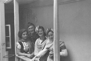 Reisefotos Spanien. Spanischer Armeeangehöriger und drei junge Spanierinnen in Trachten auf einer Innenhofgalerie