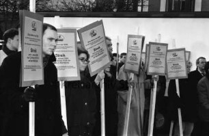 Gemeinschaft Oldesloer Kaufleute (GOK): Protestaktion gegen geplante Erhöhung der Parkgebühren: Markt: Kaufleute mit Pappschilder: hinten Stand von Wochenmarkt: 5. Januar 2000