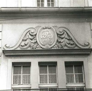 Cottbus, Karl-Liebknecht-Straße 58a. Hotel und Gaststätte "Alte Welt" (um 1910, 1925). Mittelrisalit, Fenster mit Kartusche (Monogramm IB, bezeichnet 1925)