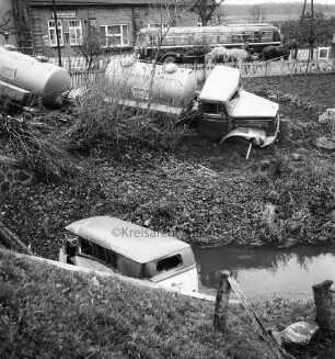Verkehrsunfall: Kalkgraben / Einmündung in Hamburger Chaussee - B 75 / Brücke über Heilsau: Zementlastwagen mit Anhänger schräg auf Böschung: Wäscherei-Lieferwagen in Heilsau: hinten Straße Kalkgraben, Lattenzäune, Reisebus, Pferdefuhrwerk mit Heu, dahinter Haus: im Vordergrund Widerlager der Brücke von B 75, Zaunpfosten