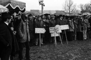 Sasbach: Kundgebung gegen Bleiwerk Marckolsheim und Atomkraftwerk Wyhl; Protestwehrversammlung im Regen mit Plakaten