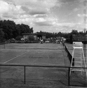 Tremsbüttel-Dorf: Sportanlagen: Tennisanlage: vorn Tennisfelder mit Netzen und Zäunen: vorn rechts Hochsitz des Schiedsrichters: hinten links Sportlerheim: rechts Flohmarktstände mit Sonnenschirmen: dazwischen Besucher