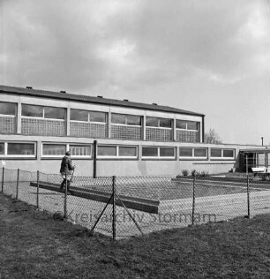 Waldstraße / Oetjendorfer Landstraße: Volksschule: Lehrschwimmbecken: vorn Zaun: links Hausmeister bei Reinigungsarbeiten: dahinter Turnhalle