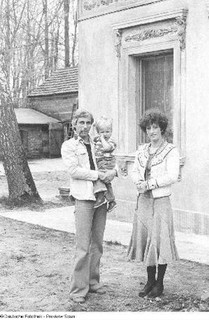 Familie mit Kind vor einem Haus