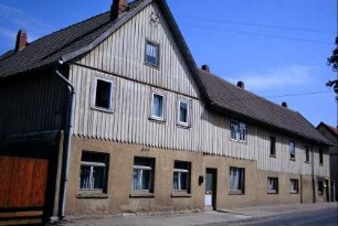 Gebäude mit Holzverkleidung im OG