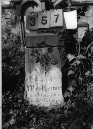 Grabstein 357 (Index: 99791761) Material: Sandstein Zustand: verwittert mit Textverlust Maße HxBxT: 53x26x18 cm Beschreibung: Obelisk Symbolik: zwei geknickte Rosen Besonderheit: Kindergrab: Grabstein 357
