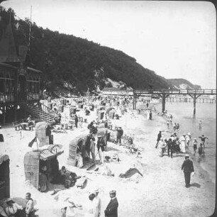 Sellin. Strand mit Restaurant, Strandkörben und Badegästen. Blick zur Seebrücke