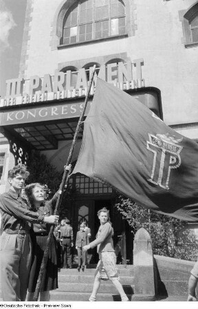 Jugendliche mit Pionierflagge vor dem Eingang zu Kongreßhalle