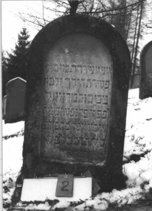Grabstein 2 (Index: 99608686) Material: Sandstein Zustand: leicht verwittert Maße HxBxT: 96x52x11 cm Beschreibung: Stele mit Rundbogen, vertiefter Textteil: Grabstein 2