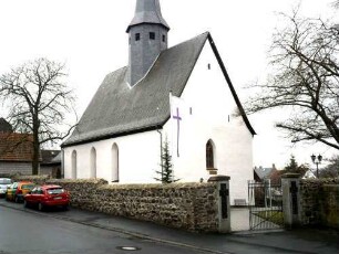 Krofdorf-Evangelische Kirche - Ansicht von Nordwesten mit Kirche (Spätromanische Gründung 13 Jh) über Kirchhofmauer (Wehrgang mit Steinbrüstung und Schießscharten abgetragen)