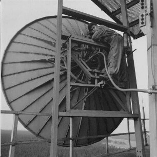 Deutsche Demokratische Republik. Osterzgebirge (bei Zinnwald-Georgenfeld). Relaisstation Lugstein für den terrestrischen Richtfunk (zwecks Programmaustausch zwischen DDR und ČSSR), Mechaniker bei Wartungsarbeiten an einer Parabolantenne