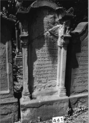 Grabstein 441 (Index: 99629942) Material: Sandstein Zustand: stark verwitt/Textverl/zerbroch/reparier Maße HxBxT: 171x73x30 cm Beschreibung: Stele auf Sock. m. eingezog. Segmentbogenabschl. m. Verdach/Schriftfeld eingetieft Symbolik: Akroterien, beidseitig Pilaster m. geschmückten Kapitellen, Rundbogenfries: Grabstein 441
