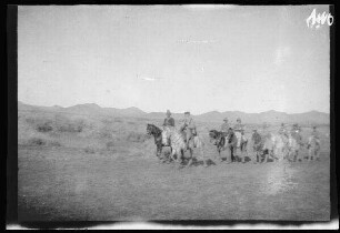 Fort Monte Arruit (südwestliche Selouane, Marokko): Major Espinosa (spanischer Generalstabsoffizier) und Baron Stolzenberg (deutscher Militärattaché) an der Spitze einer Reitergruppe [des spanischen 10. Kavallerie-Regiments "Alcántara" (?)] in hellgestreiften Uniformhosen, dunklen Uniformjacken und Tropenhelmen in freier Landschaft mit Bergland im Hintergrund