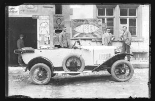Historisches Automobil, im Hintergrund vier Männer und Werbung der Fa. M. Dosch Wertheim, Opel, Continental u.a.