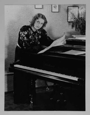 Porträt Elisabeth Reichelt (1910-2001; Koloratursopranistin) am Flügel. Reproduktionspositiv nach Fotografie von Gerhard Laßig. Staatsoper Dresden, 1942/1943