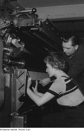 Meister mit Lehrling an einer Druckmaschine