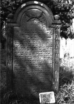 Grabstein 656 (Index: 100104934) Material: Sandstein Zustand: leicht verwittert Maße HxBxT: 170x89x14 cm Beschreibung: Stele, eingezogener Rundbogenabschluss mit Verdachung, auf den Einzügen Kugelaufsätze, Schriftfeld eingetieft, im Bogenfeld gekreuzte Akanthusblätter, an den seitlichen Rahmen Blütenfries Symbolik: Blütenfries, gekreuzte Akanthusblätter Besonderheit: kulturhistorisch wertvoll / künstl.-formale Gründe (Inschrift): Grabstein 656