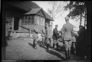 Guntowniki (=Guntauninkai, Litauen): Oberst von Schultes und weitere Offiziere in hellen und dunklen Unformjacken vor einem großen, reetgedeckten Holzhaus ("Befehlsstelle in Guntowniky")