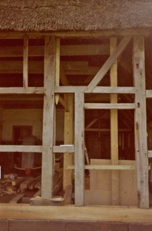 Beimoorweg (47): Fachwerkhaus mit Reetdach: bei Renovierung: Teilansicht: Gefache Außenwand ohne Ausmauerung, Blick in Innenraum, auf Boden Baumaterial