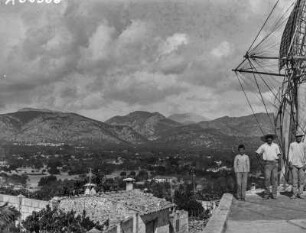 Windmühle in Inca : Drei Männer stehen auf einer Windmühle. Im Hintergrund die Kleinstadt Inca und Gebirge