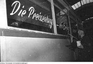 Dresden, VEB Verkehrsbetriebe der Stadt Dresden. Mitarbeiter beim Beschriften eines Straßenbahnwagens "Die Preissenkung - ein Erfolg unserer ...", Oktober/November 1953