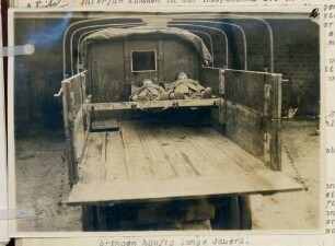 Foto eines zum Transport von Verwundeten eingerichteten Lastkraftwagens mit zwei Soldaten beladen