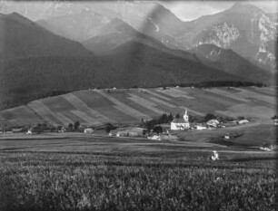 Dorf im Tal : Ein Dorf von Feldern umgeben in einem Tal. Im Hintergrund hohe Berge