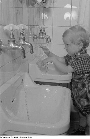 Kleines Mädchen beim Waschen im Waschraum