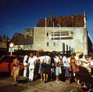 In Stralsund an der Ostsee stehen Leute Schlange vor dem Kaufhaus, eil etwas besonderes angeboten wird, Foto ca. 1980