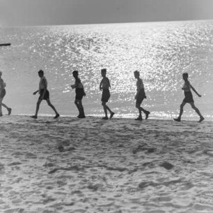 Jugendliche laufen am Strand entlang