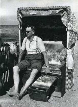 Mann mit Sonnenbrille sitzt im Strandkorb