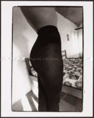Frau in Strumpfhose vor einem Bett (Altersgruppe 18-21)