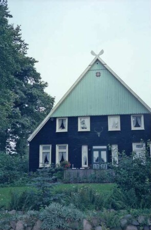 Hohe Leuchte: Bauernhaus, Fachwerkbau: Giebelseite Wohntrakt: über Tür Geweih, Giebel mit Verbretterung, Giebelzier Pferdeköpfe: vorne Garten, Feldsteinmauer