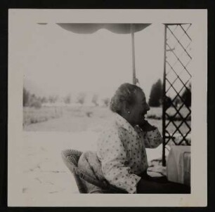 Gerty von Hofmannsthal in einer gepunkteten Bluse im Garten sitzend