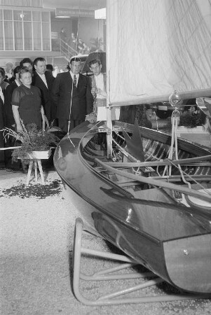 Mehrere Personen betrachten ein auf der Leipziger Herbstmesse 1955 ausgestelltes Segelboot