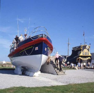 Großbritannien. Cornwall bei Land's end. Ein altes Segelschiff und ein Seenotrettungskreuzer stehen zur Besichtigung an Land