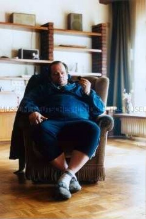Älterer, männlicher Heimbewohner in einem Sessel sitzend (Prämiertes Foto)
