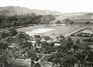 Tongking, Vietnam. Dorf mit Reisflächen in der Ebene des Song Chai (Roter Fluß), im Hintergrund ein im Schwemmland untertauchenden Höhenrücken