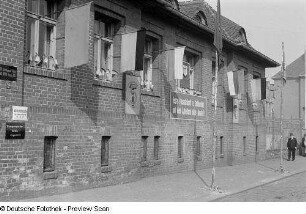Mit Fahnen und politischer Propaganda geschmücktes Haus