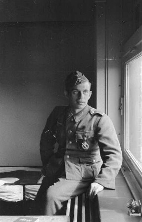 Zweiter Weltkrieg. Niederlande unter deutscher Besatzung. Unterkunft deutscher Wehrmachtsangehöriger (wohl bei Den Haag). Wehrmachtsangehöriger, am Fenster sitzend