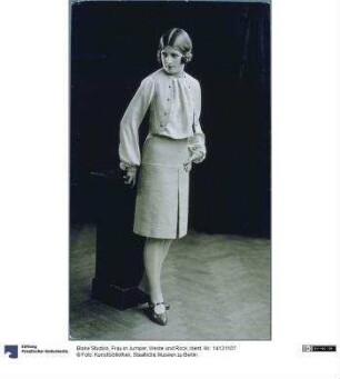 Frau in Jumper, Weste und Rock