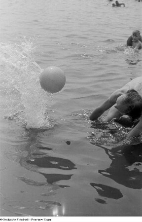 Mann im Wasser, mit einem Ball spielend