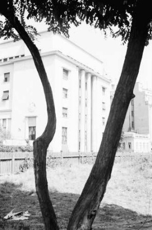 Bukarest: Haus Ugir, Außenansicht, Säulen, Vordergrund Baumstämme